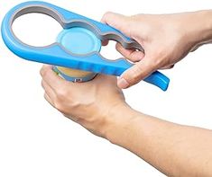 a person holding a blue and gray scissors in their left hand with the handle extended