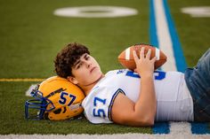 a boy laying on the ground with a football