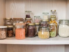 jars filled with different types of food sitting on a shelf next to other containers and nuts