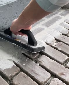 a person using a squirt to clean bricks