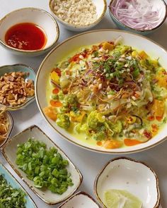 a table topped with bowls filled with different types of food and sauces on top of it