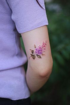 a woman with a flower tattoo on her arm