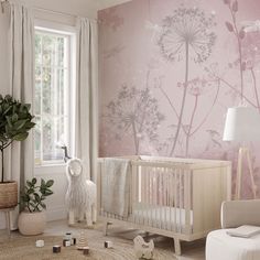 a baby's room decorated in pink and white with flowers on the wall, crib