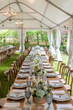 a long table is set up with place settings and napkins for guests to eat