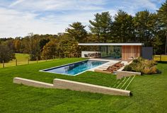 a house with a pool in the middle of it and grass on the ground next to it