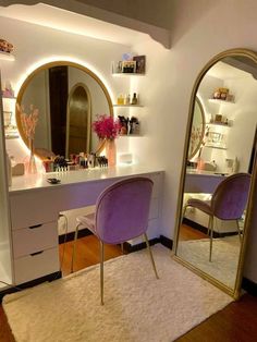 a vanity with two chairs and a large mirror on the wall next to each other