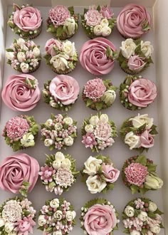 cupcakes decorated with pink and white flowers in a box