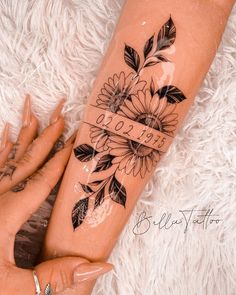 a woman's leg with tattoos and flowers on it