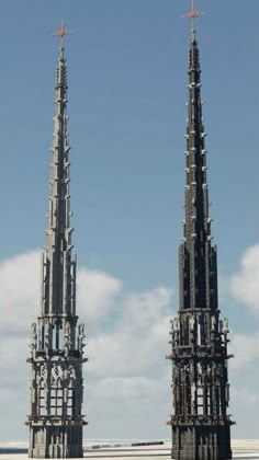 two very tall buildings sitting next to each other on top of a field in front of a blue sky