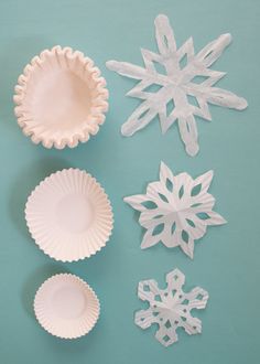 paper snowflakes and plates on a blue background with one being cut out to look like an ornament