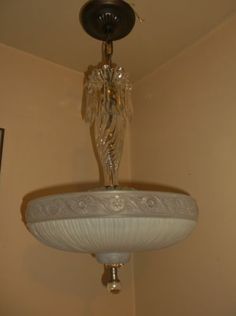 a chandelier hanging from the ceiling with an angel figurine on it