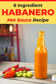 an orange sauce in a glass bottle next to peppers and other vegetables on a wooden table