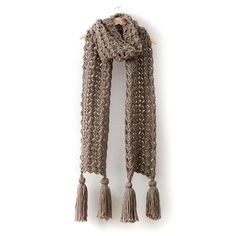 a brown scarf with tassels hanging on a wall