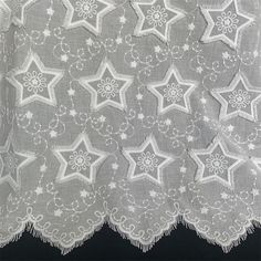 a white doily with stars on it sitting on top of a black table cloth