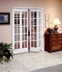 a living room filled with furniture and lots of glass doors on the door to another room