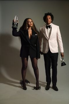 a man and woman in tuxedos posing for a photo