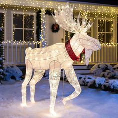 a lighted reindeer in front of a house