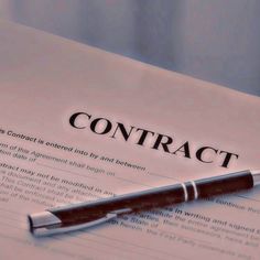 a pen sitting on top of a paper with the word contract