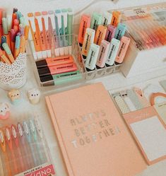 an assortment of stationery items including pens, markers and notebooks on a table