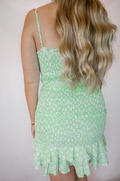 This mint green floral smocked dress features a ruffled hem and adjustable straps. The model is wearing a size small. Flirty Green Dress With Ruffled Straps, Green Spaghetti Strap Dress With Smocked Back, Green Dress With Smocked Bodice And Spaghetti Straps, Green Sundress With Tiered Skirt, Green Tiered Skirt Sundress, Green Tiered Sundress, Green Spaghetti Strap Dress With Smocked Bodice, Green Dresses With Ruffled Straps For Spring, Cute Spring Smocked Dress With Ruffles