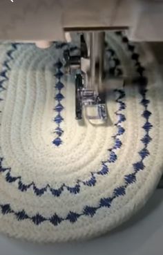 a close up of a machine that is working on some material with blue and white designs