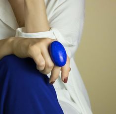 a close up of a person holding a blue object in their left hand and wearing a white shirt