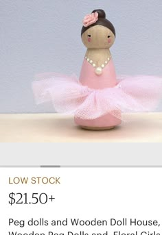 a doll is sitting in a pink ballerina dress on a table with the price tag below it