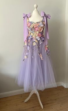 Unique dress consisting of 3D flowers. The dress is made of floral lace and lavender tulle, thanks to which it looks extremely elegant and subtle on the body. The bodice of the dress is on a flesh-colored mesh and is hand-decorated with flowers. There are flesh-colored cups sewn into the corset. The shoulders are crowned with bows that add a romantic touch. The upper part of the dress is laced, and the bottom is zippered, which makes it easier to dress. The lower part of the dress consists of a Pastel Prom Dress, Ren Faire Costume, Dress Pastel, Flowers Dress, Dress Party Night, Unique Outfit, Dress Unique, Bridesmaids Dress, Dress Purple