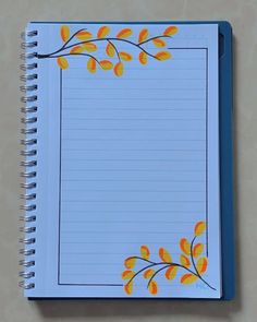 an open spiral notebook with yellow leaves on blue lined paper, next to a pen