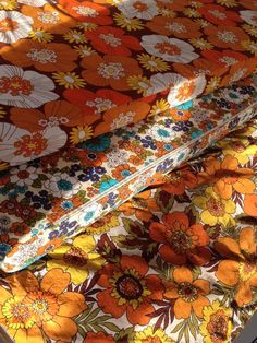 three different types of fabric with orange flowers on them and one yellow flower in the middle