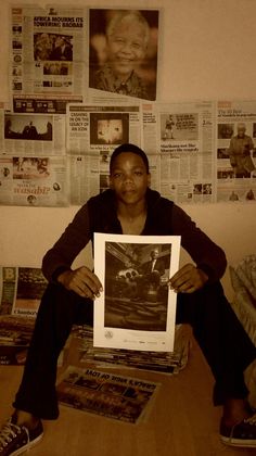 a woman sitting on the floor holding up a framed photo