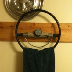 a towel hanging on the wall next to a pot holder with a metal object in it