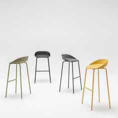 three stools in different colors and sizes on a white background, one is black, the other is yellow