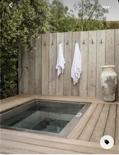 an outdoor hot tub with towels hanging on the wall