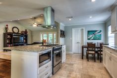 a kitchen with an oven, stove and dining room table