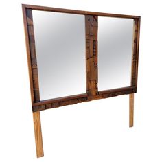 a large wooden mirror with two mirrors on it's sides and one is made out of wood