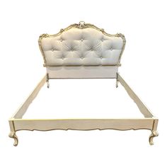 a white bed with gold trim and headboard