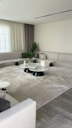 a living room with white couches and tables