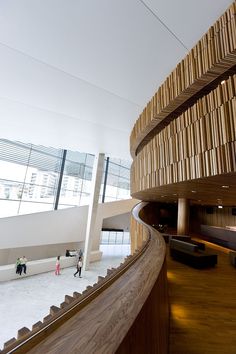 people are walking up and down an escalator in a building with wooden walls