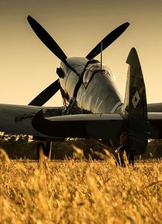 an old airplane is parked in the grass