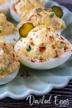 deviled eggs on a plate with pickles and seasoning