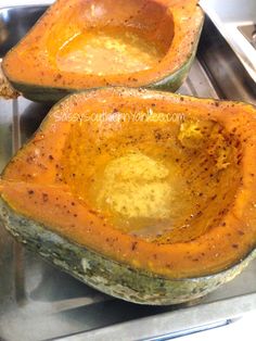 two acorns sitting on top of a metal pan filled with something yellow and brown