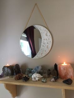 there is a mirror and some rocks on the shelf