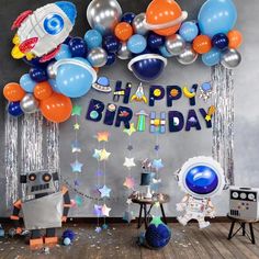 an astronaut themed birthday party with balloons and streamers on the wall, space theme