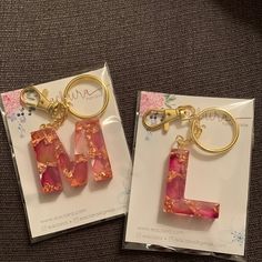 two key chains with the letter l on them