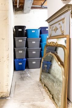 a mirror sitting on top of a floor next to some bins