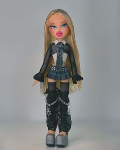 a doll with long blonde hair wearing black and white clothes, boots and tights