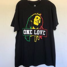 Bob Marley One Love Brand New Officially Licensed Screen Print Adult Men's T-Shirt. 100% Cotton Large Chest 22” Length 29” Bob Marley One Love Graphic T Shirt Bob Marley One Love, Bob Marley Shirts, Blue Jean Overalls, Love Graphic, Queen Shirts, Gaming Shirt, One Love, Mens Short Sleeve Shirt, Tour Shirt