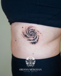 a woman's stomach with a spiral tattoo on it