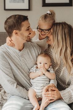 a man, woman and baby are sitting on a couch